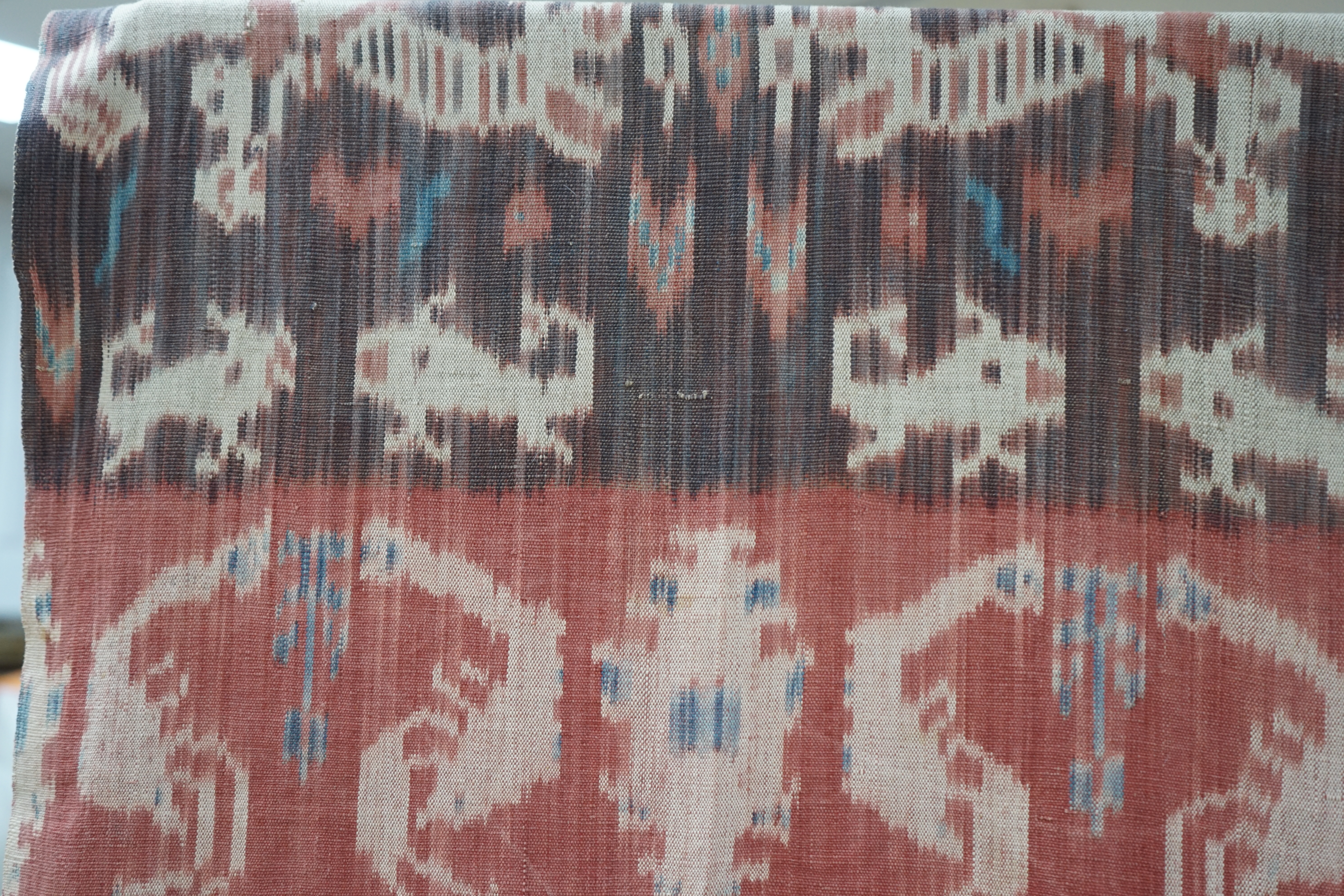 A hand woven hand dyed Ikat Sumbanese Hinggi (shoulder cloth), together with an Indian chain stitch embroidered panel, the Hinggi woven on two short 56cm wide looms sewn together forming horizontal bands, depicting men o